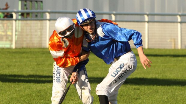 Jockey James Doyle is helped up by counterpart Blake Shinn after the fall in the Sydney Cup.