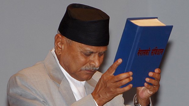 Nepalese President Ram Baran Yadav displays the constitution, formally adopted following a decade of political infighting, in Kathmandu on Sunday.