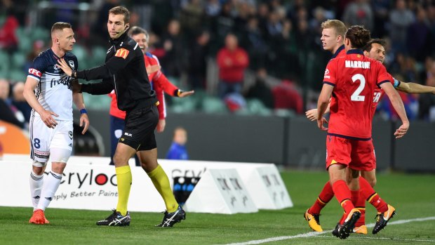 Besart Berisha tangles with a referee in round three at Adelaide Oval.