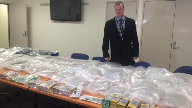 Detective Senior Sergeant Tony Geary with some of the drugs, cash and other items uncovered across Logan.