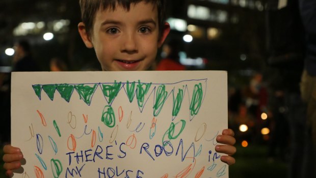 "There's room in my house" says a sign held by Xavier, who is just two years older than Aylan Kurdi, at the Light the Dark rally in Sydney. 