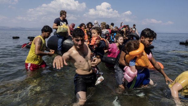 A small boat with refugees reaches safety on the Greek coast at Lesvos. 