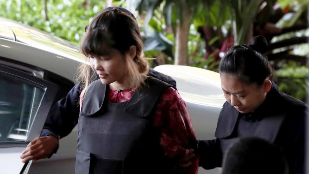 Vietnamese Doan Thi Huong, left, is escorted by police as she arrives for the court hearing.