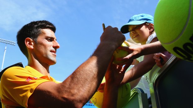 Sign here, please: Novak Djokovic autographs after his match against Alexandr Dolgopolov.