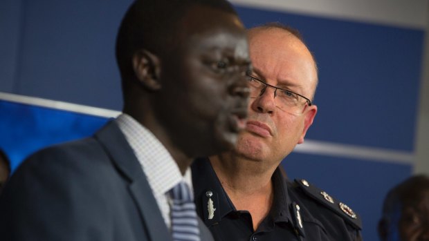 Police Commisioner Graham Ashton listens to African community leader Kot Monoah at a press conference on Wednesday.