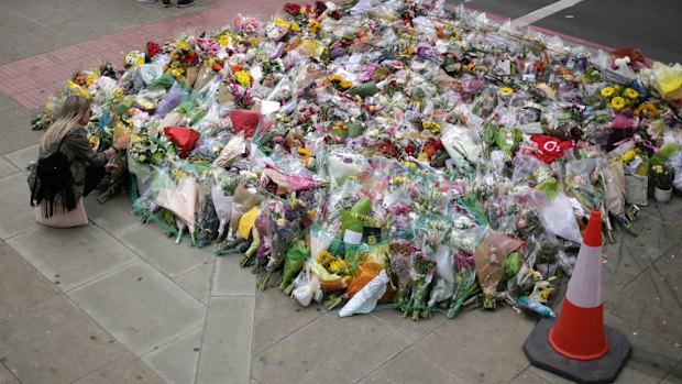 A woman looks at a floral tribute near London Bridge, where eight people died and dozens were seriously injured.