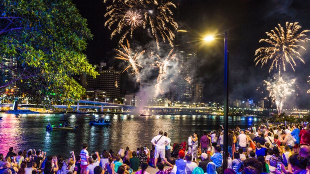 Crowds at South Bank watch as the skies above Brisbane explode with New Year's Eve fireworks.