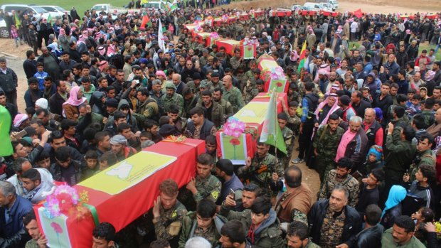 Fighters from the predominantly-Kurdish Syrian Democratic Forces carrying the coffins of their comrades, who were killed Tuesday by a misdirected airstrike by the US-led coalition.