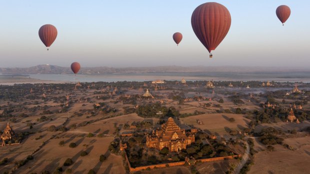 Balloons fly over Dhammayangyi Temple, with the Irrawaddy River in the background.