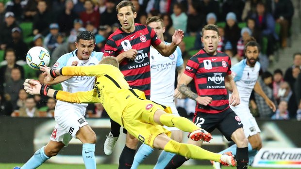 City's Tim Cahill competes for the ball as Western Sydney goalkeeper Andrew Redmayne makes a save.