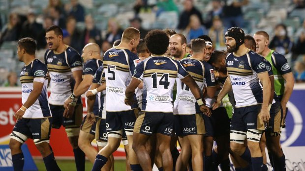 The Brumbies celebrate a try against the Queensland Reds.