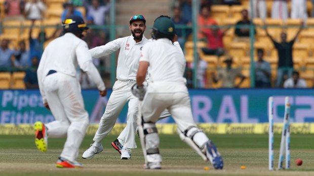 Sniffing victory: Under fire India captain Virat Kohli  celebrates the dismissal of Australia's Steve O'Keefe.