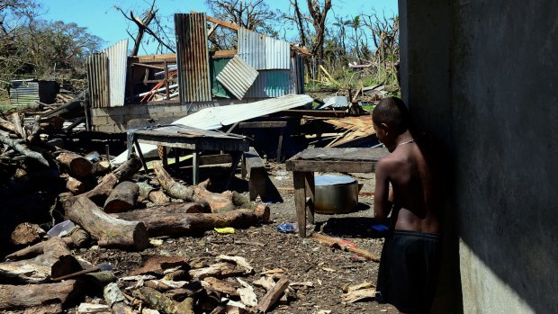 A young boy looks at the debris of his home, badly damaged by Cyclone Pam on the Vanuatu island of Tanna on March 18.