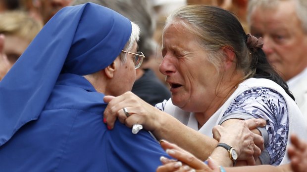 French nun grieves with a woman during a gathering in a town park for a solemn homage to slain priest Father Jacques Hamel in Saint-Etienne-du-Rouvray, Normandy