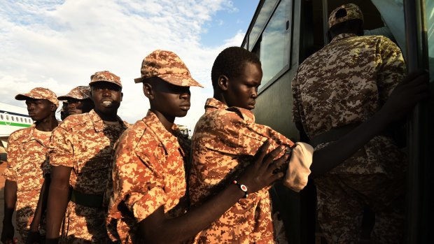 Back in the fold: Rebel soldiers board the bus to their camp at Juba airport.