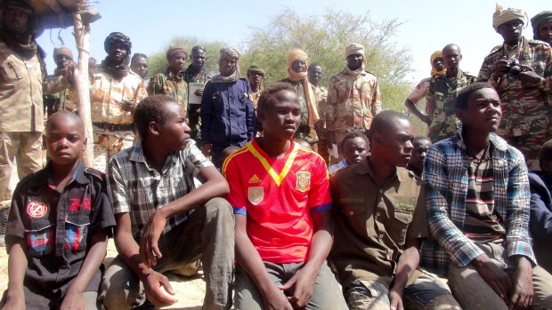 Former members of insurgent group Boko Haram gather in front of Chadian soldiers in Ngouboua, Chad in April.