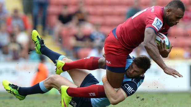 Heading for a fall:  Eto Nabuli of the Reds is tackled during the match against the Waratahs.