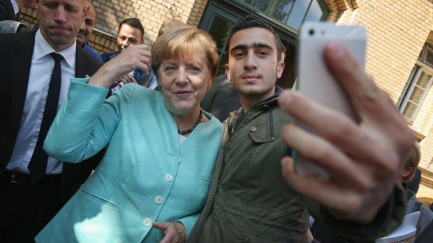 German Chancellor Angela Merkel poses for a selfie with a migrant from Syria in Berlin. Germany is expecting to receive 800,000 asylum applicants this year.