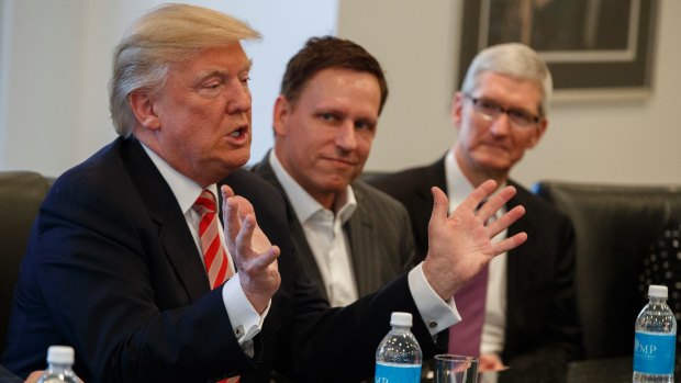 Peter Thiel, centre, listen as President-elect Donald Trump speaks during a meeting with technology industry leaders on December 14. 
