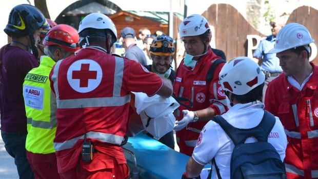 Rescue crews remove a body from a collapsed building at Amatrice.