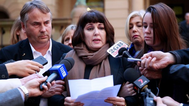 Members of the Kelly family, Ralph, Kathy and Madeleine, face the media outside court in 2013.