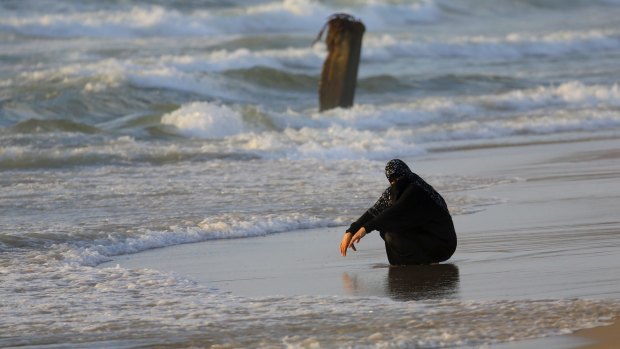 A veiled woman cools off at a beach of the Mediterranean Sea on a sweltering hot day along the coast of Gaza City last week.