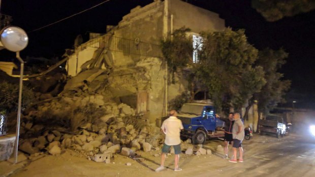 People standing near a collapsed building following an earthquake in Casamicciola on the Italian resort island of Ischia.