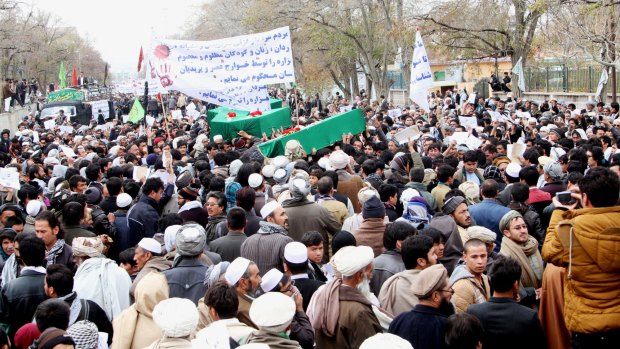 Afghan men carry seven coffins of the slain Hazara in Ghazni province on Tuesday.  