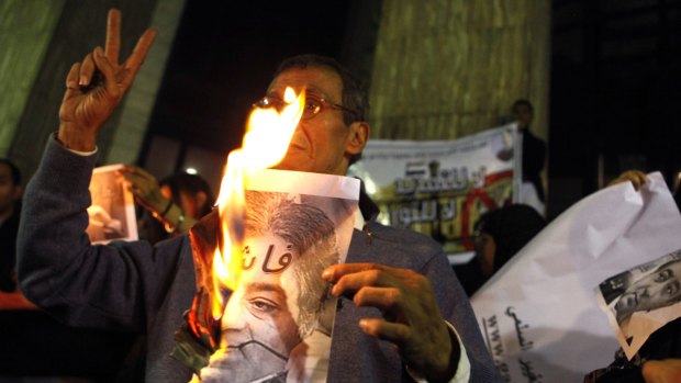 A demonstrator burns a picture of Ahmed Ezz, then a prominent candidate of the ruling National Democratic Party, at a protest in 2010. 