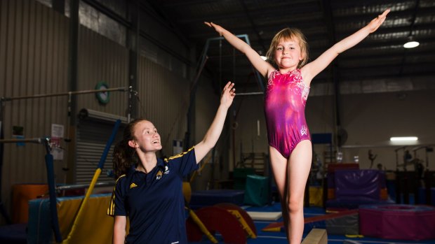 Seven-year-old Sophie Waddell became Gymnastics Australia's 200,000th registered participant when she joined the Southern Canberra Gymnastics Club. Seven-year-old Sophie Waddell with world cup medalist Naomi Lee. Photo: Jamila Toderas