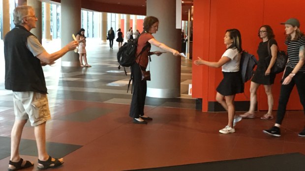 Louise Sales and (left) Bob Phelps of Gene Ethics hand out pamphlets at the Melbourne Convention Centre during the forum. 