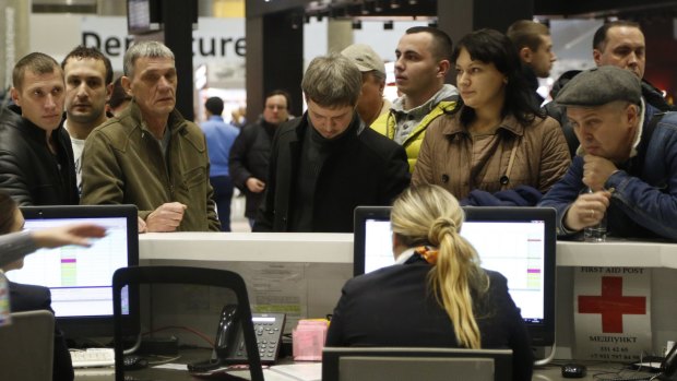 People gather at the airline information desk at Pulkovo Airport in St.Petersburg.