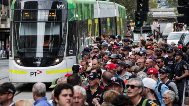 Big crowds wait in line to catch a tram to the Grand Prix on Friday.