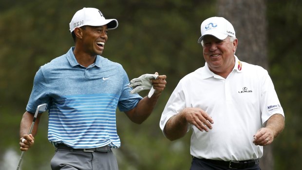 Tiger Woods shares a laugh with Mark O'Meara as they walk up the fourth fairway.