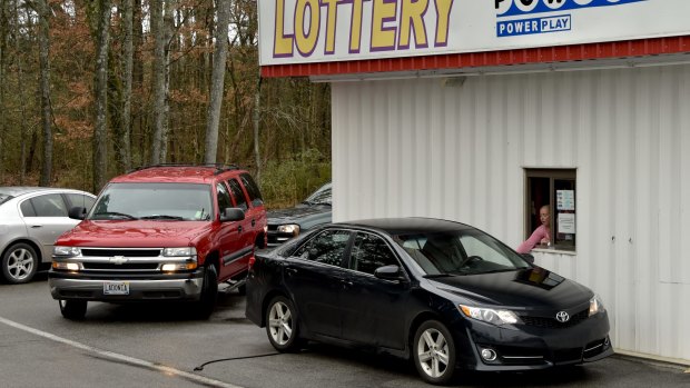 Motorists line up at the Jackpot Express lottery store drive through to purchase lottery tickets a day before Saturday's Powerball drawing.