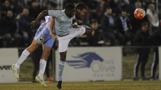 Belconnen's Danai Gapare clashes with Sydney FC's Matthew Jurman in Wednesday night's pre-season friendly at McKellar Park.
