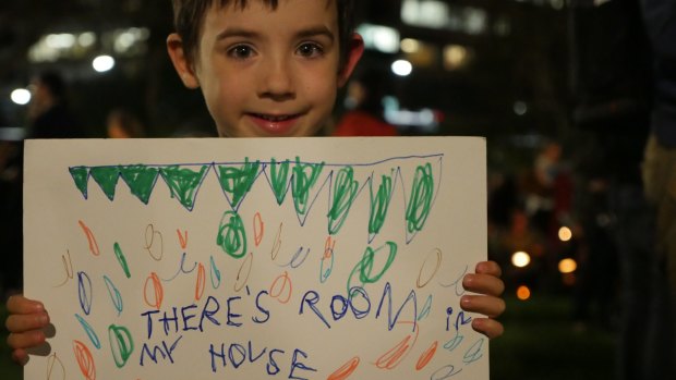 Cecilia Egan's son Xavier, 5, holding his home made sign at the Light The Dark vigil in Hyde Park, Sydney