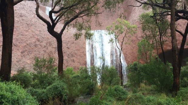 Heavy rain creates a waterfall at Uluru.