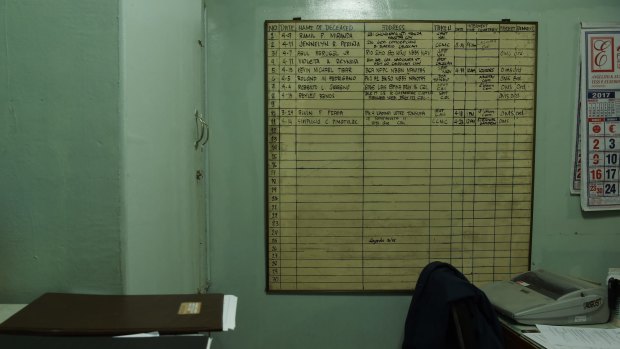 A list of bodies hangs on the wall of a funeral home in Manila.