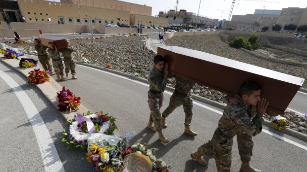 Armed Forces of Malta soldiers carry coffins with the bodies of migrants to the service.