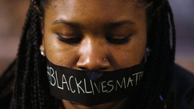 A protester wears tape over her mouth during a silent demonstration against what they say is police brutality after the Ferguson shooting of Michael Brown.