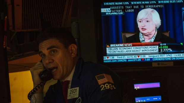 A trader at the New York Stock Exchange makes a call last year as Federal Reserve boss Janet Yellen talks about the economy.