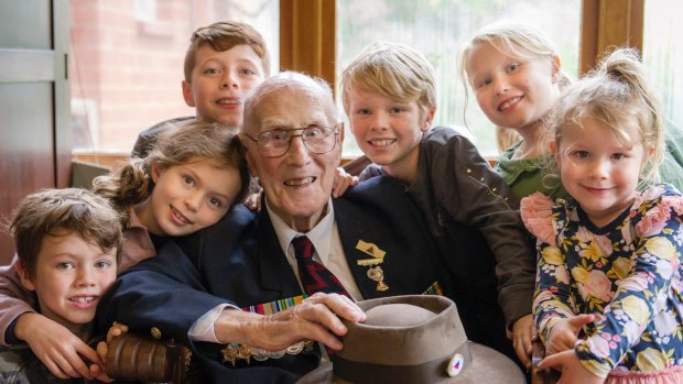 WWII veteran John Hendry surrounded by great-grandchildren after participating in the 2017 Anzac Day National Ceremony.