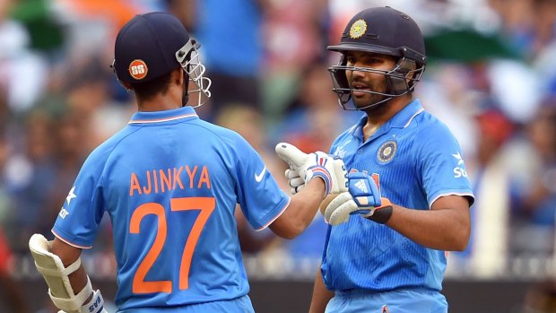 Milestone: India's Ajinkya Rahane congratulates fellow batsman Rohit Sharma on scoring runs at the MCG.
