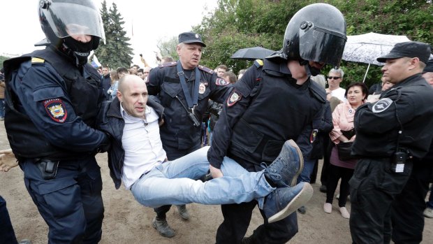 Police detain a protester during an anti-corruption rally in St Petersburg, Russia.
