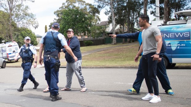 Relatives clash with police and media at the scene of Tuesday's fatal shooting in Georges Hall.