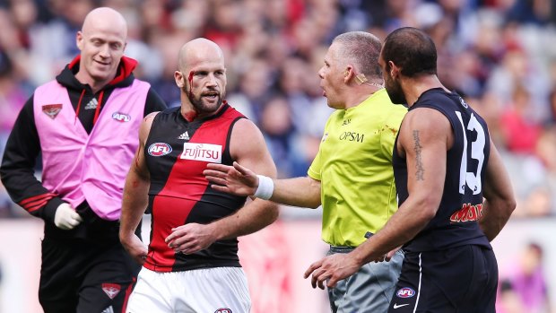 The umpire intervenes in a confrontation between Paul Chapman of the Bombers (left) and Chris Yarran of the Blues.