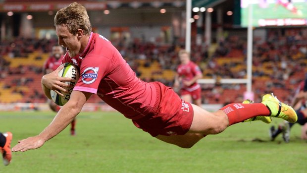 Lachlan Turner of the Reds dives over to score against the Melbourne Rebels at Suncorp Stadium.