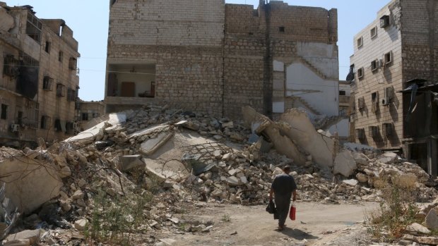 A man walks along a damaged street in the al-Katerji district in Aleppo, Syria.