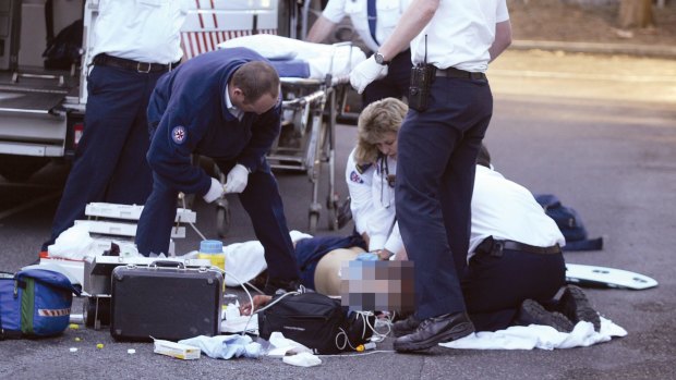 Ambulance officers try to revive the 14-year-old girl, who was stabbed numerous times at Forresters Beach.